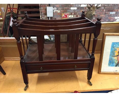 A MAHOGANY CANTERBURY MAGAZINE RACK ON VINTAGE CASTERS 