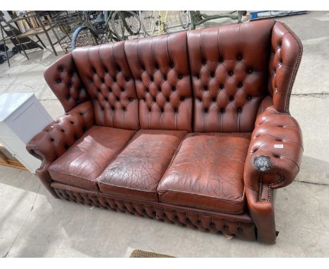 AN OXBLOOD BUTTON-BACK THREE SEATER SETTEE 