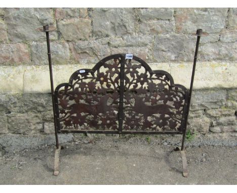 An arts and crafts style fire screen with fretted detail showing running foxes, with candle sconce ends, 71cm wide 