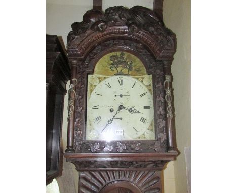 A 19th century oak longcase clock with heavy estate carving, the trunk detailing a knight fighting serpents, the hood with tr