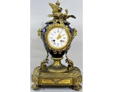 A 19th century gilt metal and porcelain mantle clock, the white enamelled dial with blue Roman and black Arabic numerals, set