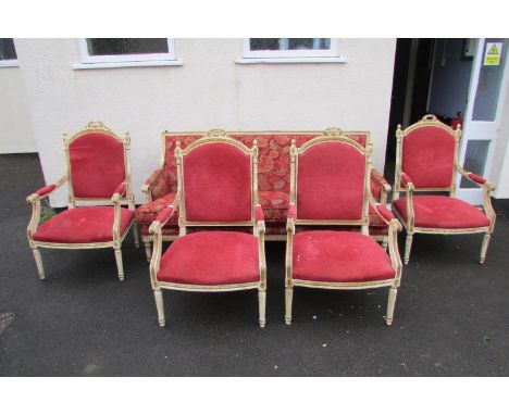 A French drawing room suite comprising a three seat sofa and four matching tub chairs, the frames with carved, painted and gi