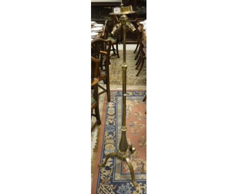 A brass telescopic standard lamp in the Victorian taste raised on a tripod base 