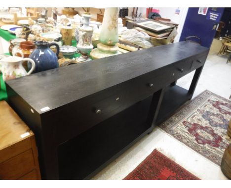 A modern ebonised oak dresser with plain top over four drawers on square supports united by a pot shelf by Stewart Brick of T