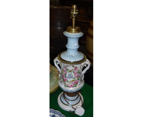 A 19th Century Continental porcelain oil lamp of urn form with polychrome rose and floral decoration, together with a transfe