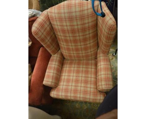 A wingback armchair with orange and red check upholstery on mushroom coloured ground together with a red upholstered two seat