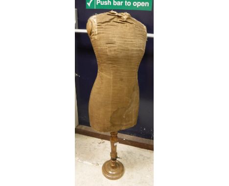 A vintage tailor's dummy with canvas-covered body raised on a wooden telescopic ringed support and turned base