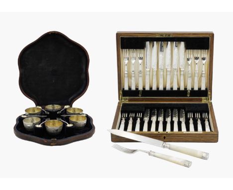 A Victorian cased set of six silver-plated salts and spoons. The bowls have fluted and foliate embossed with gilded interiors