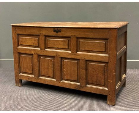 A late 17th century oak chest, the three plank cleated top with iron loop hinges above a panelled front raised on stile feet8