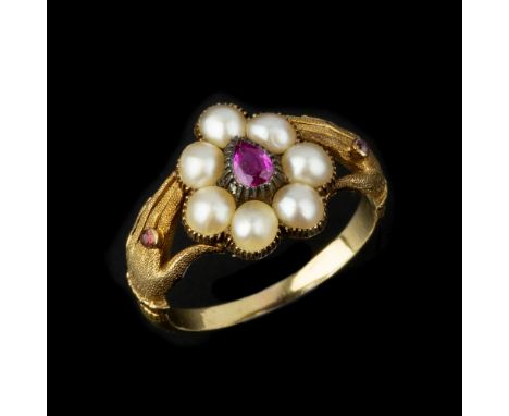 A half pearl and ruby ring, the central pear shaped ruby within a surround of half pearls, between hand shaped shoulders, wit
