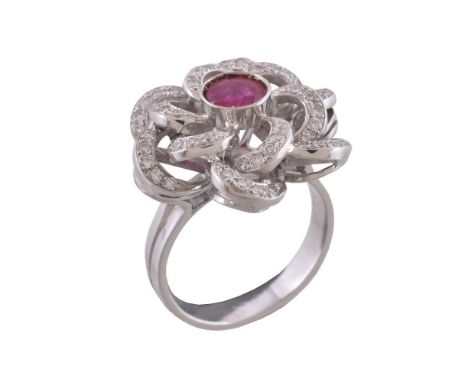 A ruby and diamond cluster ring, the central circular cut ruby estimated to weigh 1.02 carats, within a scrolling surround se