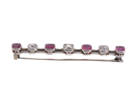 A ruby and diamond bar brooch, set with alternating old mine cut diamonds, approximately 0.60 carats total, and cushion cut r