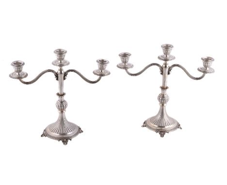 A pair of Italian silver coloured three light candelabra by Piero Arioli, 1944-68 .800 standard, with beaded rims to the flut
