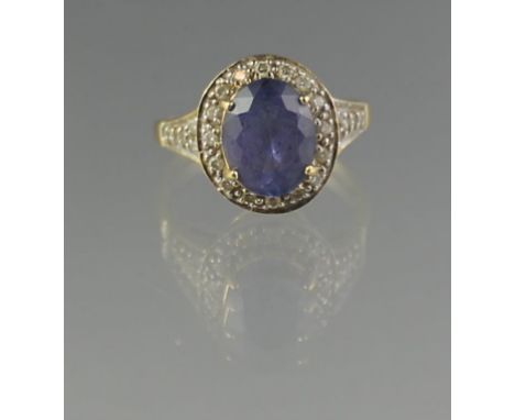 18CT GOLD OVAL TANZANITE AND DIAMOND RING. Diamond 9 x 7mm approx. Ring size N & 1/2. Weight 3.8g approx. (B.P. 21% + VAT) Co