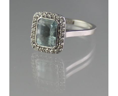 18CT WHITE GOLD AQUAMARINE AND DIAMOND RING. The step cut aquamarine surrounded by diamonds. Ring size M. Weight 3.7g approx.