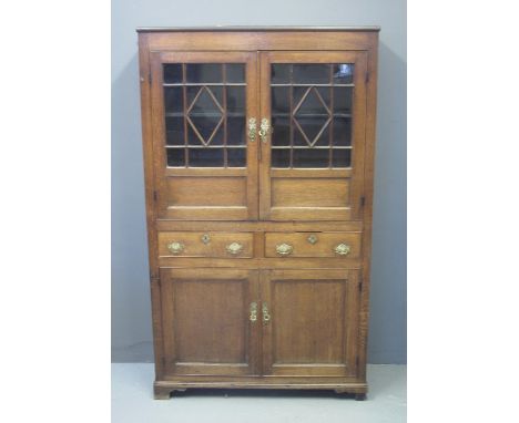 EARLY 19TH CENTURY WELSH OAK BOOKCASE CUPBOARD having two glazed doors, the interior revealing two fitted ebonised shelves ab