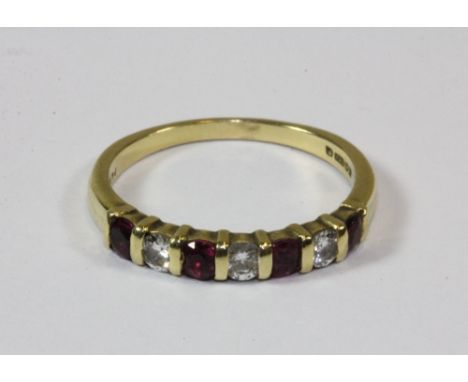 An 18ct gold ruby and diamond half eternity ring (M).