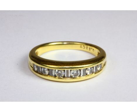 A heavy 18ct yellow gold ring set with brilliant and baguette cut diamonds (K.5).