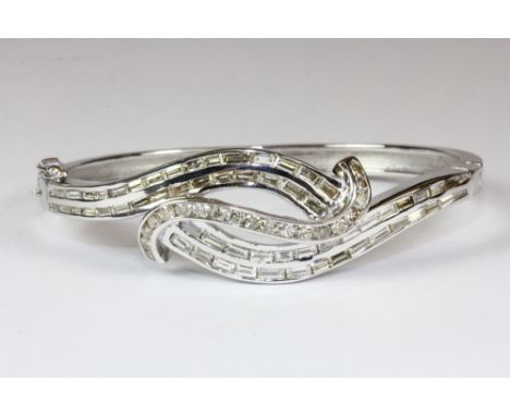 A superb 18ct white gold hinged bangle set with baguette and brilliant cut diamonds. Est. £2,000 - 2,500