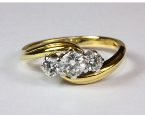 An 18ct yellow gold, three stone diamond crossover ring, (K.5).