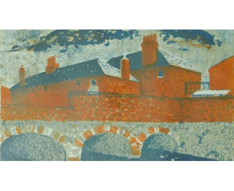 A mid century framed and glazed lino/woodblock print of a bridge across a river with brick houses in the background. Unsigned
