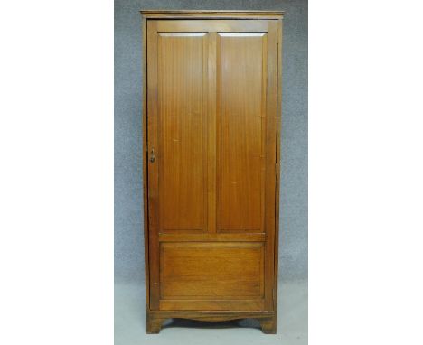 A vintage teak hall cupboard with panel door enclosing shelves on bracket feet. H.176 W.76 D.51cm 