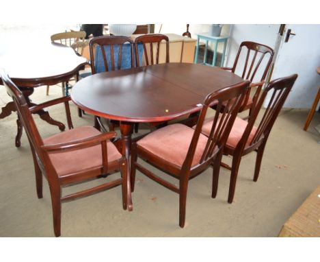 A reproduction mahogany extending dining table with a set of six matching chairs to include two carvers 