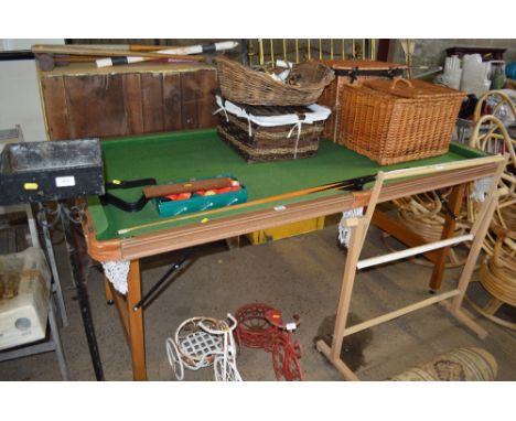 A small folding snooker table with a set of balls and cues