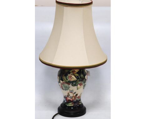 Moorcroft table lamp decorated with tube-lined flowers on a cream and blue ground, 19cm high, with shade. 