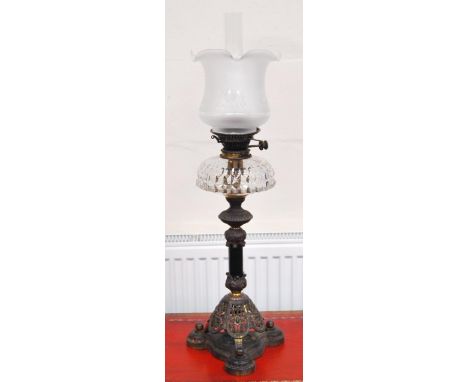 Late Victorian oil lamp with a Hinks lever, the glass reservoir above an ornate metal column and pierced mount, on a trefoil 