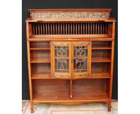 Shapland & Petter of Barnstaple fine Arts & Crafts walnut motto bookcase, the shelved gallery with a copper repoussé panel be