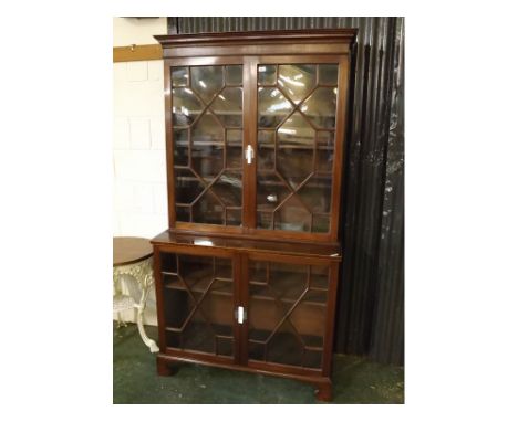 19th century mahogany glazed two-tier display cabinet, the top section of two geometric astragal glazed doors beneath a sprea