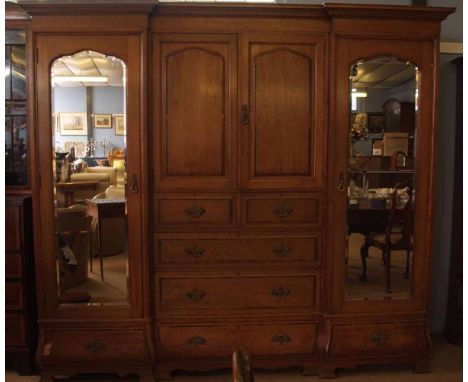 Late 19th/early 20th century large light oak compendium wardrobe, with breakfront dentil cornice, two central panelled doors 