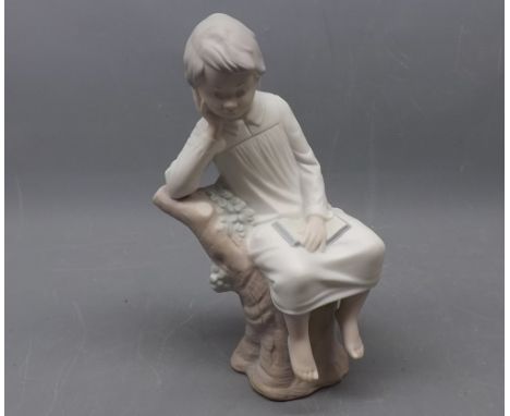Lladro model of a young boy in his nightgown sitting on a tree trunk, 9ins tall 
