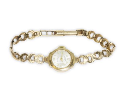 A Whittles 9ct gold ladies wristwatch with integrated 9ct gold strap, gross weight 11.6g.