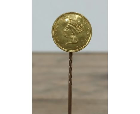 An 1857 USA one dollar gold coin soldered on a stick pin.