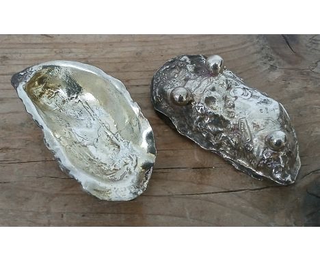 A pair of cast salts realistically modelled as oyster shells stood on three ball feet, marked CJ, SILVER and LIVERPOOL, lengt