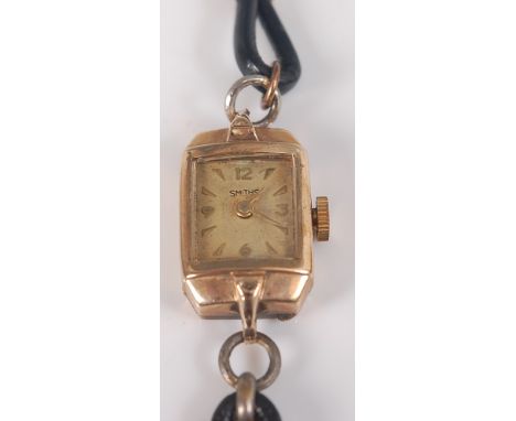 A yellow metal Smiths manual wind wristwatch, with champagne rectangular quarter Arabic dial and fitted to a black leather st
