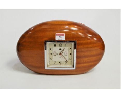 A 1950s Smiths walnut cased mantel clock, having a square dial with Arabic numerals and alarm apertures, the dial signed Smit