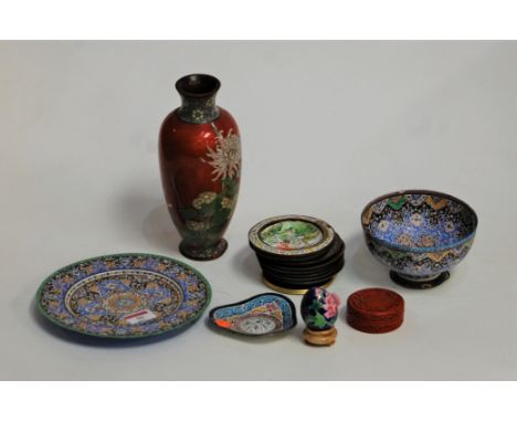 An early 20th century Japanese cloisonné vase, of baluster form, on a red ground decorated with flowers, h.21cm; together wit