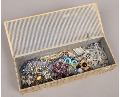 An embroidered glove box containing assorted 1950s costume jewellery.