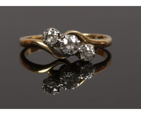 A gold and platinum three stone diamond ring, size K.