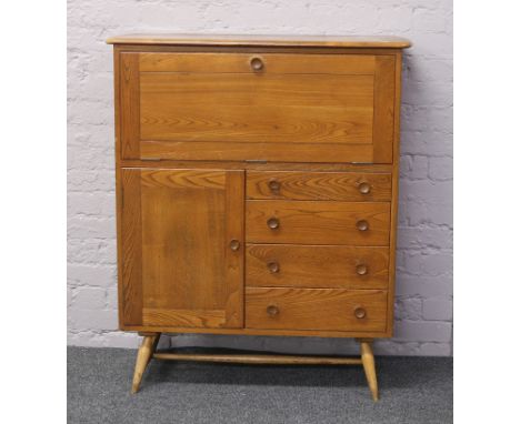 An Ercol Golden Dawn carved and panelled oak drinks cabinet.
