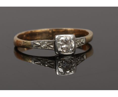 An Art Deco yellow metal solitaire diamond ring with diamond set shoulders, principle stone approximately 0.25ct, size M.