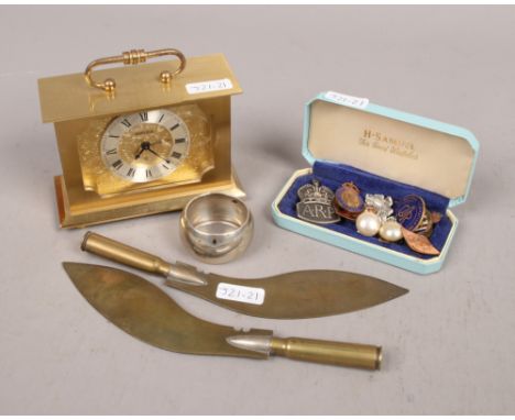 A group of collectables to include brass Swiza clock, silver napkin ring, enamel badges etc.