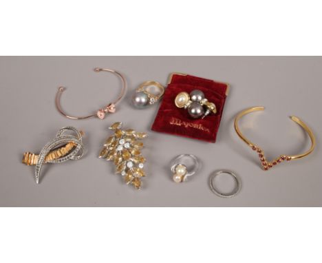 A small box of white and yellow metal dress jewellery including Majorca simulated pearl ring etc.