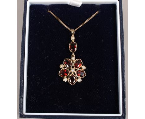 A 9ct gold garnet and pearl cluster pendant on 9ct gold chain. (not diamond as originally cataloged)&nbsp;