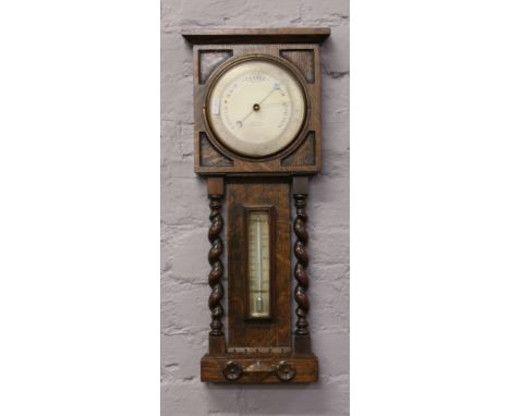 An oak wall barometer with barleytwist supports.