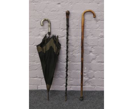 A Hawthorn ebonized walking cane, another walking stick and a parasol.