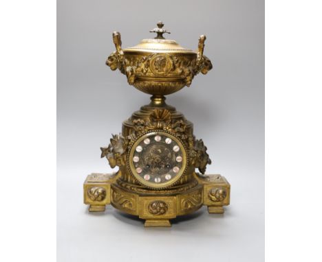 A French gilt metal mantel clock, designed with ornate vines and an urn,38 cms high,